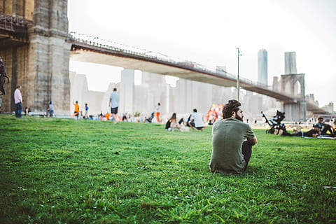 man, sitting, green, grass, brooklyn bridge, photo, top, black, bottoms, crowd, people, near, bridge, guy, field, architecture, New York, city, urban, NYC, buildings, lifestyle, group, built structure, building exterior, large group of people, adult, adults only, men, women, real people, group of people, incidental people, nature, day, rear view, lifestyles, plant, leisure activity, tourism, outdoors, architectural column, 5K