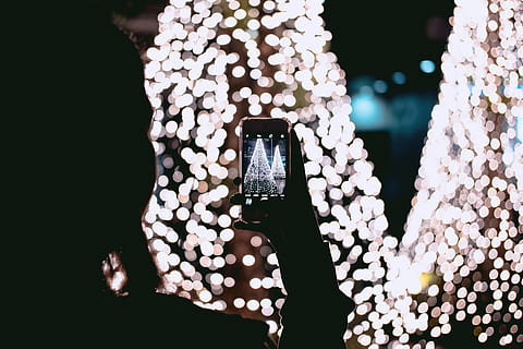 person, taking, picture, christmas trees, photo, lights, night, dark, tree, christmas, technology, mobile phone, smart phone, wireless technology, portable information device, photography themes, photographing, holding, connection, communication, screen, illuminated, using phone, telephone, one person, photo messaging, activity, device screen, adult, outdoors, light, 5K, CC0, public domain, royalty free
