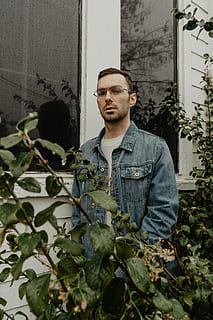 om, purtare, albastru, denim jacket-up-up, verde, frunze, permanent, fereastră clădire, plantă, jacheta denim, timpul zilei, portret, ochelari, reflecţie, privind camera, o persoana, tânăr adult, oameni adevărați, stiluri de viață, Barbat tanar, creştere, Activitatea de agrement, haine casual, vedere din față, construită, arhitectură, parte a plantelor, zi, uitându-se departe, contemplare, în aer liber, 5K, CC0, domeniu public, fără drepturi de autor