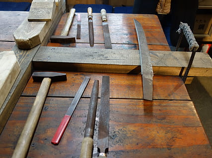 sword, roughing, before processing, wood - material, high angle view, no people, workshop, work tool, indoors, table, hand tool, day, tool, art and craft, old, group of objects, hammer, still life, metal, flooring, wood, equipment, 2K, CC0, public domain, royalty free