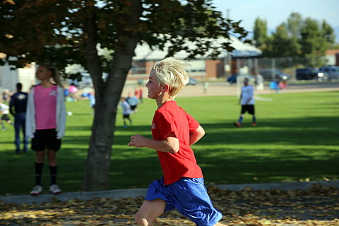 niño, corriendo, árbol, camisa roja, carrera, al aire libre, deporte, infancia, personas incidentales, hierba, gente real, planta, hombres, muchachos, estilos de vida, jugando, machos, equipo de deporte, día, fútbol, actividad de ocio, centrarse en primer plano, gente, grupo de personas, 5K, CC0, dominio público, libre de derechos