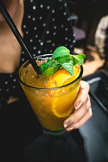 orange, juice drink, mint, Orange juice, drink, bar, close up, hands, cocktail, fruit, ice, freshness, alcohol, food, juice, summer, refreshment, cold - Temperature, citrus Fruit, close-up, food and drink, adults only, drinking straw, people, adult, real people, one person, focus on foreground, household equipment, holding, leaf, herb, drinking glass, lifestyles, glass, mint leaf - culinary, straw, hand, 5K