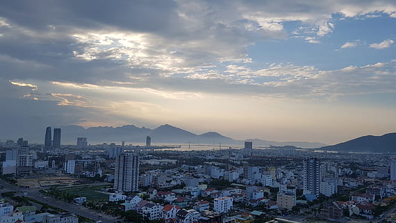 sunset, city, glow, cloud, cbd, building, in the evening, architecture, building exterior, built structure, cityscape, sky, cloud - sky, travel destinations, residential district, nature, high angle view, office building exterior, mountain, city life, landscape, crowded, skyscraper, outdoors, 4K, CC0, public domain, royalty free