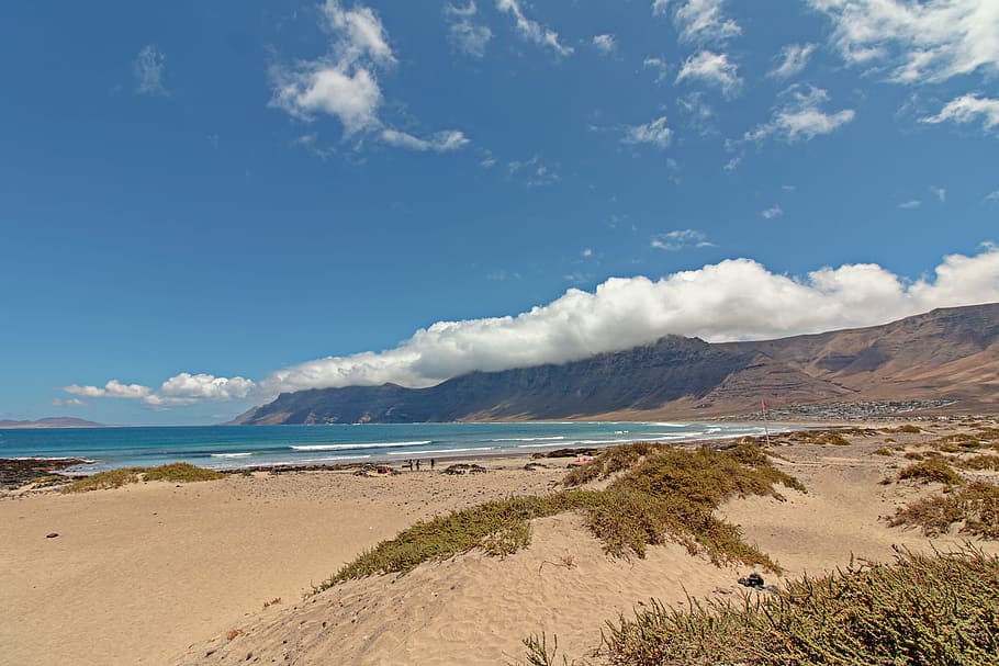 hav, landskab, bjerge, natur, strand, skyer, dagslys, klitter, græs, ocean, udendørs, mennesker, sand, naturskøn, marinemaleri, kysten, himmel, vand, bølger, jord, sky - himmel, skønhed i naturen, scenics - natur, dag, ro, rolig scene, ikke-urbane scene, idyllisk, bjerg, ingen mennesker, sollys, marram græs, 2K