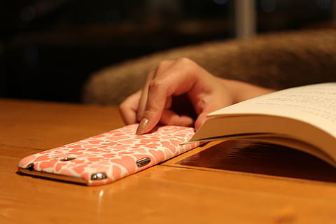 book, hand, cellphone, case, human hand, human body part, indoors, one person, adult, table, holding, publication, close-up, selective focus, women, relaxation, activity, lifestyles, young adult, leisure activity, casual clothing, finger, 5K, CC0, public domain, royalty free