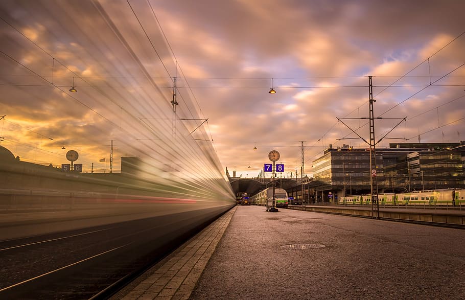 Foto, Zug, Bahnhof, Zeitraffer Fotografie, Dienstpost, Spur, Himmel, Sonnenuntergang, wolke - himmel, Transport, die Architektur, Transportmittel, Bewegung, gebaute Struktur, Bewegungsunschärfe, Gebäudehülle, Schienenverkehr, Stadt, Natur, öffentliche Verkehrsmittel, Bahngleis, Verbindung, Reise, draußen, Geschwindigkeit, Bürogebäude außen, 5K