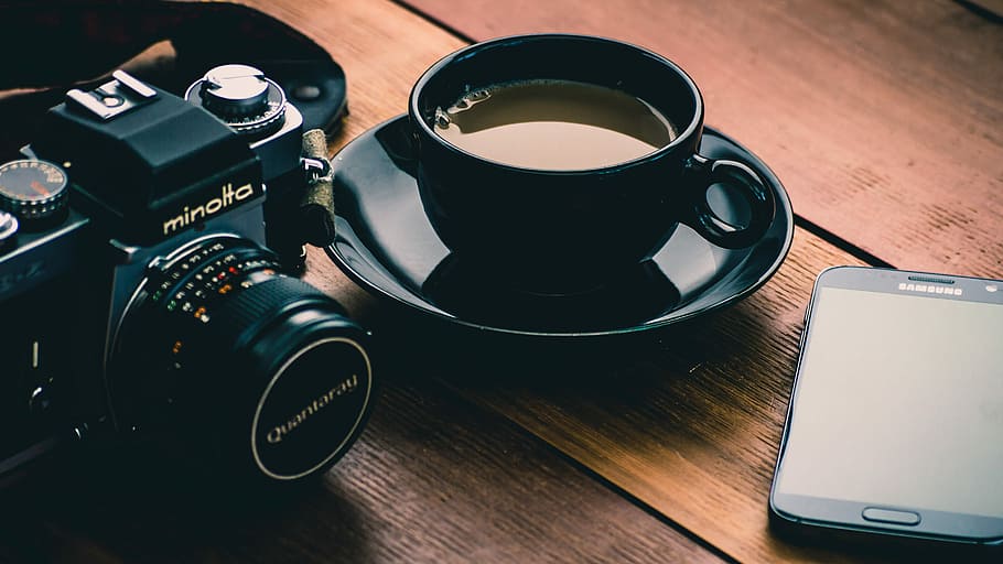 schwarz, Minolta Kamera, neben, Kaffee, gefüllt, Keramik, Tasse, Kaffeetasse, Untertasse, Minolta DSLR-Kamera, Smartphone, Kamera, Minolta, Tee, Schreibtisch, Telefon, Samsung, Mobiltelefon, Tabelle, hölzern, Technologie, kabellose Technologie, Becher, Kommunikation, Getränk, Kamera - Fotoausrüstung, Verbindung, Essen und Trinken, Fotografie-Themen, High Angle View, drinnen, Stillleben, Kaffee trinken, keine Leute, Erfrischung, Nahansicht, Digitalkamera, Geschirr, modern, Teetasse, 2K