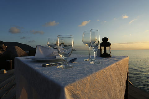 fire, tom, vinglas, hvid, dug, legeme, vand, gylden, time, solnedgang, vente, aftensmad, strand, bord, restaurant, udendørs, hav, service, romantisk, drikkeglas, afspejling, glas, vin, forfriskning, drikke, mad og drikke, alkohol, himmel, husholdningsudstyr, natur, skønhed i naturen, scenics - natur, sky - himmel, glas - materiale, horisont over vand, ingen mennesker, indstilling, luksus, 5K, CC0, offentligt domæne, royaltyfrie