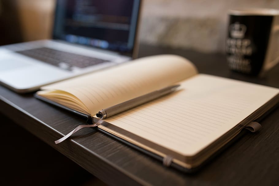 poc profund, focus, diari, bolígraf, llibre, obert, quadern, buit, línies, lloc de treball, escriptori, taula, paper, negocis, oficina, pàgina, llapis, en blanc, ordinador, treballar, portàtil, material de fusta, tecnologia sense fils, tecnologia, comunicació, connexió, a l'interior, cap gent, publicació, natura morta, bloc de notes, educació, enfocament selectiu, mobles, teclat, 5K