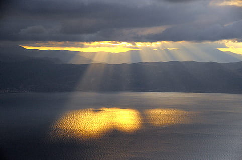 sun rays, body, water, dark, clouds, setting sun, heaven, twilight, sea, orange, nature, rays, vote, reflection, abendstimmung, cloud - sky, sky, mountain, sunset, beauty in nature, scenics - nature, no people, environment, sunlight, yellow, mountain range, storm, dramatic sky, landscape, tranquility, outdoors, 4K, CC0, public domain, royalty free