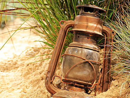 brown, gas lantern, sand, daytime, lantern, lighting, light, light source, lamp, beach, plant, metal, metal lantern, no people, old-fashioned, outdoors, day, close-up, old, retro styled, land, rusty, oil lamp, field, abandoned, nature, focus on foreground, obsolete, grass, lighting equipment, single object, electric lamp, antique, 4K, CC0, public domain, royalty free
