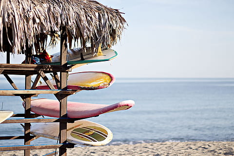 vermell, blanc, taula de surf, marró, fusta, prestatge, taules de surf, refugi, navega, botiga, estiu, platja, mar, vacances, línia de costa, sorra, a l'aire lliure, aigua, relaxació, clima tropical, naturalesa, idíl·lic, destinacions de viatge, cap gent, llocs de viatges, complex turístic, blau, cel, escena tranquil·la, viatjar, platges, paraigua, dia, terra, horitzó sobre l’aigua, bellesa a la natura, festa, horitzó, tranquil·litat, escenics - natura, centrar-se en primer pla, viatge, 5K, CC0, domini públic, lliure de regalies