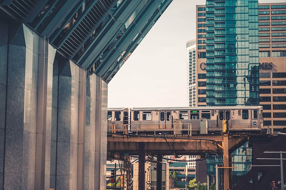 gris, tren, foto del focus, arquitectura, edifici, infraestructura, ferrocarril, viatjar, transport, ciutat, urbà, escena urbana, paisatge urbà, gratacels, estructura construïda, districte del centre de la ciutat, exterior de l'edifici, horitzó urbà, pont, pont - estructura feta per l'home, connexió, dia, barri residencial, cap gent, exterior d’edifici d’oficines, modern, cel, columna arquitectònica, a l'aire lliure, manera de transport, naturalesa, 5K