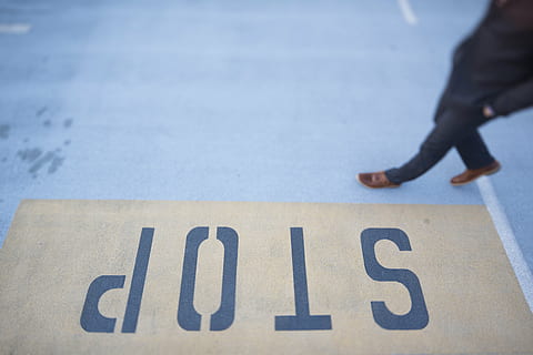 person waling, gray, floor, yellow, black, stop, road, lane, sign, pedestrian, walking, intersection, pavement, street, text, one person, low section, human body part, people, adult, day, outdoors, one man only, adults only, communication, number, body part, western script, focus on foreground, symbol, city, standing, motion, single word, direction, selective focus, human limb, 5K, CC0, public domain, royalty free