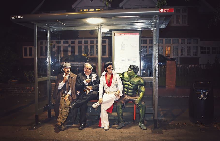 quatre, homes, seient, gris, cadira de banc de metall, superheroi, sherlock, Hulk, elvis, moda, disfressa, festa, carrer, urbà, carnaval, roba, colorit, esperant, nit, heroi, ric, aniversari, felicitat, comèdia, feliç, expressió, màscara, longitud completa, grup de persones, dones, adult, arquitectura, comunicació, de peu, adult jove, roba casual, unió, exterior de l'edifici, gent, dones joves, estructura construïda, mascles, home jove, botiga, ciutat, 4K