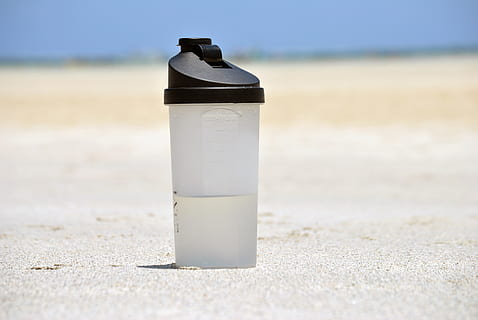 tumblr, sòl, durant el dia, ampolla, aigua, plàstic, contenidor, beure, embotellat, set, calenta, calor, estiu, platja, desert, sorra, terra, dia, naturalesa, llum solar, primer pla, cap gent, a l'aire lliure, centrar-se en primer pla, sol objecte, menjar i beguda, còpia espai, assolellat, en blanc, 4K, CC0, domini públic, lliure de regalies