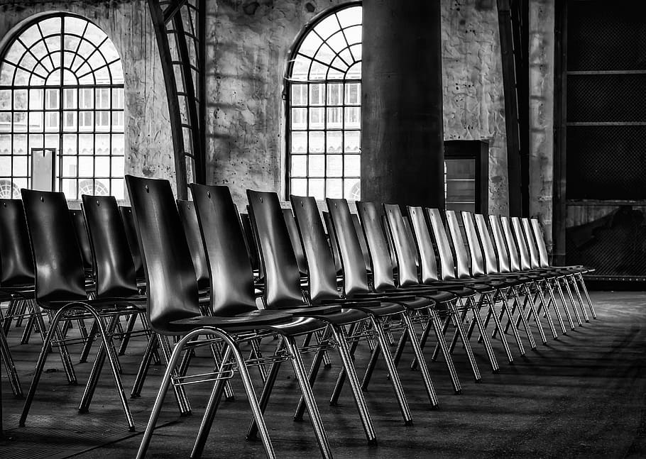 fotografia en escala de grisos, cadires sense braç, cadires, sèrie, seure, fila, sala, esdeveniment, seient, sèrie de cadires, seients, buit, cadires buides, alineació, negre blanc, públic, espectadors, endins, en fila, a l'interior, finestra, cap gent, cadira, arquitectura, absència, dia, estructura construïda, repetició, edifici, vell, costat a costat, sòls, arranjament, columna arquitectònica, 5K