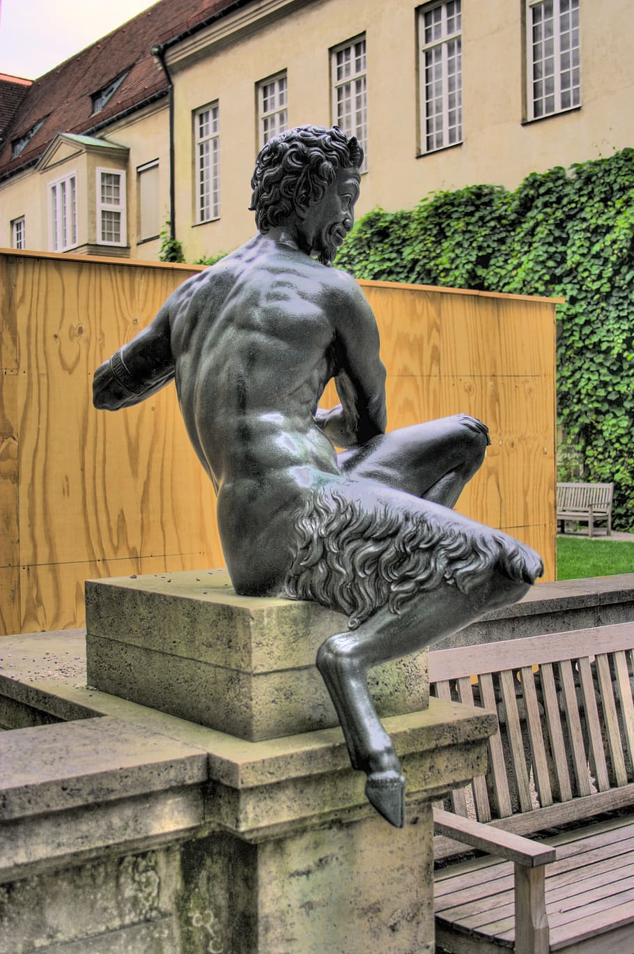 diable de bronze, munich, residència, estàtua, escultura, arquitectura, lloc famós, representació, art i artesania, representació humana, semblança masculina, exterior de l'edifici, estructura construïda, dia, banc, creativitat, cap gent, artesania, edifici, ciutat, naturalesa, a l'aire lliure, seient, 2K