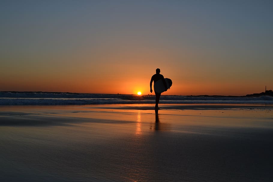 Mann, Tragen, Surfbrett, Gehen, Ufersand, Surfen, Sonnenuntergang, Strand, Silhouette, Meer, Reflexion, Wasser, Natur, eine Person, szenen, Himmel, Schönheit in der Natur, Szenen - Natur, Land, Horizont, orange Farbe, Horizont über Wasser, echte Menschen, Ruhe, Lebensstile, ruhige Szene, Freizeitbeschäftigung, Sonne, draußen, 4K