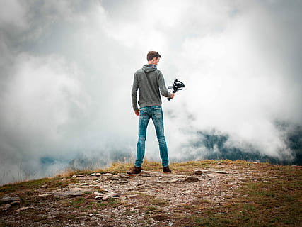 Mann, holding, kamera, stabilisator, stående, kamera stabilisator, vendt, cumulus skyer, toppmøte, Sky, filming, fjell, full lengde, én person, tåke, menn, sky - himmel, voksen, aktivitet, uformelt antrekk, fritidsaktivitet, natur, himmel, dag, utendørs, røyk - fysisk struktur, fotturer, jeans, 2K, CC0, offentlig domene, opphavsrett gratis