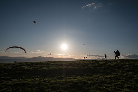 person, standing, mountain, walking, grass, field, blue, sky, mountaineer, people, men, adventure, outdoor, green, clouds, sunlight, sunshine, sunset, parachute, hiking, leisure activity, real people, nature, sun, landscape, outdoors, silhouette, lifestyles, two people, beauty in nature, sport, environment, full length, land, paragliding, unrecognizable person, recreational pursuit, 5K, CC0, public domain, royalty free