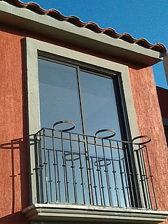 balcony, ceiling, window, construction, house, wall, facade, wall stone, grating, plant pot, glass, architecture, built structure, building exterior, low angle view, building, day, no people, sky, sunlight, nature, glass - material, outdoors, safety, security, metal, blue, railing, clear sky, protection, wrought iron, 2K, CC0, public domain, royalty free