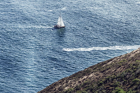 white, sailboat, sea, sailing, yacht, top, large, body, water, ocean, blue, wave, nature, green, grass, highland, boat, adventure, outdoor, transportation, nautical vessel, day, outdoors, no people, sailing ship, mode of transportation, beauty in nature, high angle view, scenics - nature, motion, rock, tranquility, rock - object, yachting, 2K
