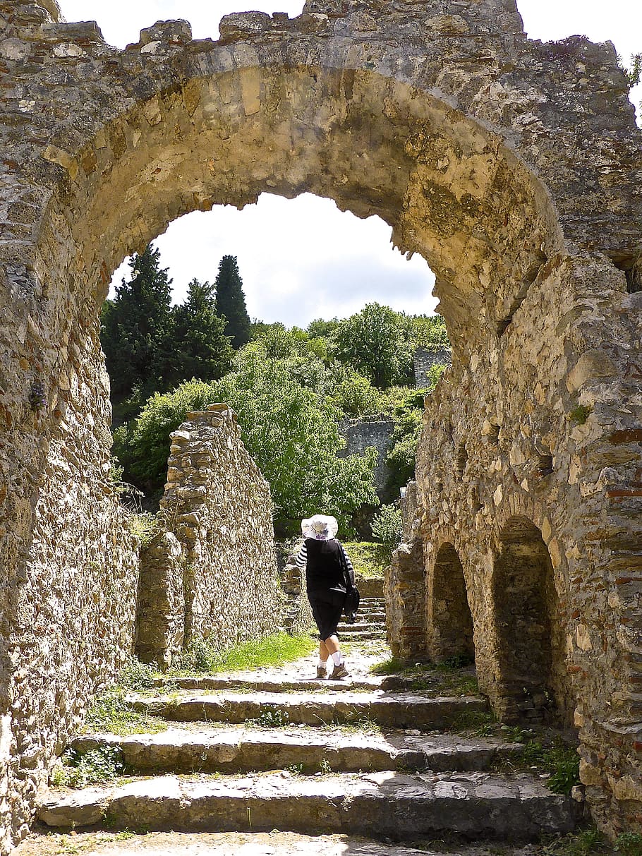 Camí, entrada, passos, porta, arc, arcada, passarel·la, sendera, antic, mystras, arquitectura, antiga ruïna, material de pedra, història, lloc famós, a l'aire lliure, gent, el passat, vell, estructura construïda, viatjar, arruïnat, cultures, turisme, turista, europa, destinacions de viatge, arqueologia, una persona, adult, longitud completa, dia, persones reals, estils de vida, activitat d'oci, exterior de l'edifici, naturalesa, el camí a seguir, vista del darrere, dones, civilització antiga, paret de pedra, 4K