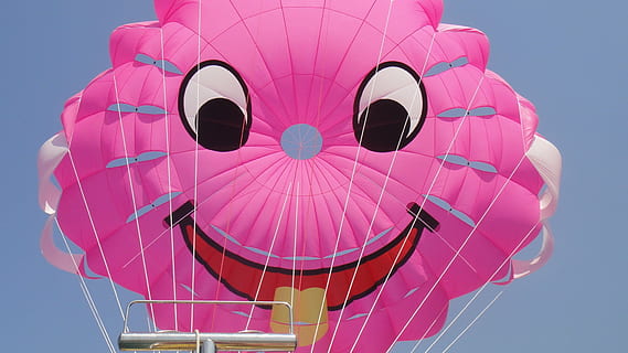 somriu, parasailing, vent, estiu, color rosa, cel, vista d’angle baix, globus, naturalesa, globus d'aire calent, cap gent, dia, transport, a l'aire lliure, arquitectura, cel clar, exterior de l'edifici, estructura construïda, multicolor, blau, vehicle aeri, diversió, assolellat, primer pla, inflable, emoció, directament a sota, 1080P, CC0, domini públic, lliure de regalies