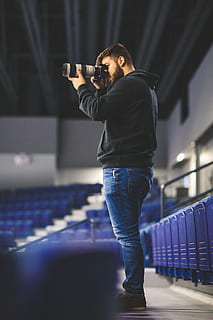mies, ottaen, kuva, stadion, käyttämällä, dslr-kamera, teleobjektiivi, henkilö, kamera, istuimet, rivi, vaihde, laitteet, kuvan ottaminen, muoti, tyyli, teknologia, tekniikka, malli-, aiheuttaa, videotyökalu, video-kamera, videotarvikkeet, Kuvaaja, videokuvaukseen, video-, nuori aikuinen, yksi henkilö, pysyvä, sisällä, arkinen vaatetus, nuoret miehet, miehet, vapaa-ajan toiminta, aikuinen, Urheilu, taiteen kulttuuri ja viihde, täyspitkä, oikeita ihmisiä, taito, yö-, valaistu, musiikki, farkut, vaihe, 5K, CC0, public domain, rojaltivapaa