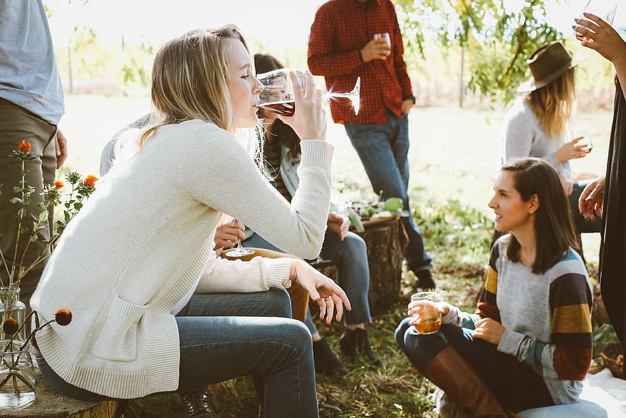 Frau, Sitzung, Menschen, Trinken, Frau trinkt, rot, Wein, braun, Stuhl vorne, Ein weiterer, Getränk, Gruppe von Leuten, Erfrischung, Freundschaft, Zusammengehörigkeit, Dreiviertel Länge, Vergnügen, Essen und Trinken, Alkohol, Feier, halten, Männer, Freizeitbeschäftigung, Glas, Erwachsene, lächelnd, soziales Zusammenkommen, 4K