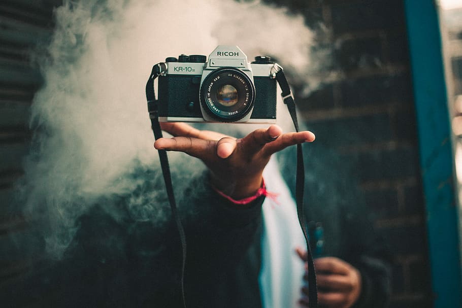 persona, captura, ricoh dslr camera, celebració, negre, càmera dslr de plata, fum, càmera, mà, truc, màgia, levitació, equipament, boira, acció, vape, càmera - equip fotogràfic, temes de fotografia, fotografiar, activitat, tecnologia, una persona, part del cos humà, mà humana, equip fotogràfic, càmera digital, fotògraf, activitat d'oci, ocupació, centrar-se en primer pla, adult, estils de vida, a l'aire lliure, càmera slr, 5K
