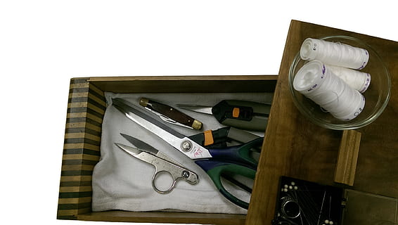 black handles shears, sewing, shears, thread, tailor, fabric, needle, spool, sew, craft, design, equipment, pin, thimble, scissors, tool, handmade, work, clothing, industry, indoors, high angle view, wood - material, work tool, no people, still life, close-up, white background, table, directly above, box - container, drawer, safety, technology, finance, box, paper, 2K, CC0, public domain, royalty free
