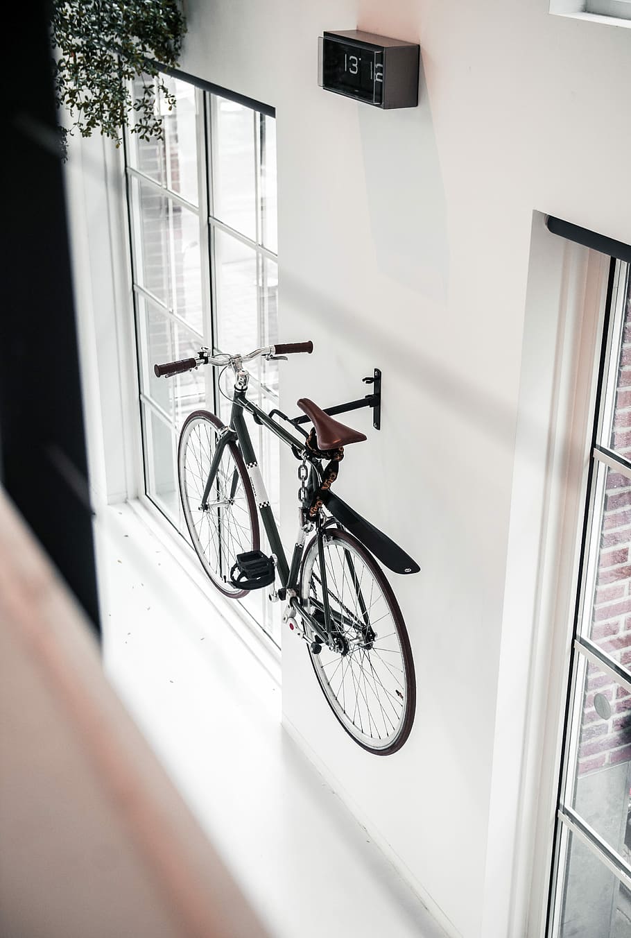 sort, mountain bike, monteret, væg, hvid, stiv, cykel, malet, dør, hængende, hænge, ur, vinduer, transportmidler, transportform, land køretøj, arkitektur, indendørs, vindue, bygget struktur, dag, murbygningsfunktion, ingen mennesker, stationær, bygning, rækværk, fravær, hvid farve, hælder, hjul, 5K