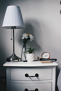 gray, metal base, white, lampshade, nightstand, closeup, photo, petaled flowers, vase, beside, table lamp, table, bedside, bedroom, clock, lamp, plant, succulent, flowers, glass, bottle, watch, shadow, drawers, chest, flowering plant, electric lamp, flower, lighting equipment, indoors, furniture, no people, domestic room, lamp shade, home interior, nature, white color, still life, freshness, beauty in nature, home, illuminated, light, side table, 5K, CC0, public domain, royalty free