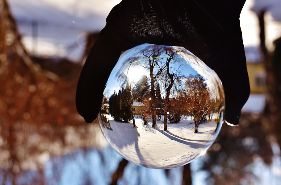 vinter, sne, have, vinterlige, glas, bold, glas bold, afspejling, tæt på, udendørs, brydning, himmel, dag, en person, fokus på forgrunden, rigtige mennesker, gennemsigtig, natur, bedrift, sfære, glas - materiale, krystalkugle, uigenkendelig person, kold temperatur, træ, livsstil, hånd, finger, 5K