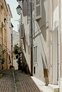 grå, gadebelysning, grøn, blad plante, sort, udendørs, væglampe, beige, højhus, bygning, blå, himmel, bygning udvendig, arkitektur, bygget struktur, by, retning, vejen frem, boligområde, gade, dag, sti, ingen mennesker, gyde, natur, smal, hus, belysningsudstyr, tom, plante, 2K, CC0, offentligt domæne, royaltyfrie