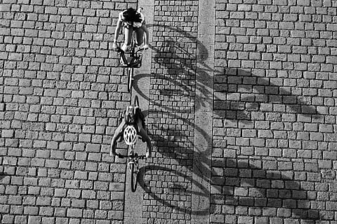round, shadow, bw, city, full length, real people, street, architecture, day, women, bicycle, one person, transportation, lifestyles, land vehicle, footpath, built structure, brick, men, mode of transportation, ride, cobblestone, riding, outdoors, paving stone, 1080P, CC0, public domain, royalty free