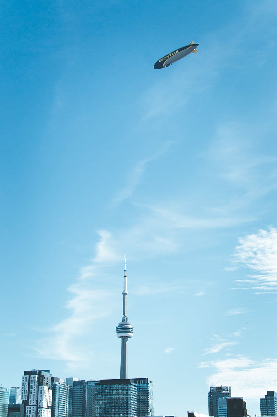 blanc, gris, Goodyear Blimp, torre d’agulla espacial, torre de cn, pres, núvols, durant el dia, cel, dirigible, gratacels, edifici, toronto, Canadà, cel blau, arquitectura, estructura construïda, exterior de l'edifici, alta - alta, vista d’angle baix, viatjar, ciutat, torre, dia, cap gent, núvol - cel, naturalesa, volant, destinacions de viatge, vehicle aeri, a l'aire, exterior d’edifici d’oficines, a l'aire lliure, fletxa, 2K