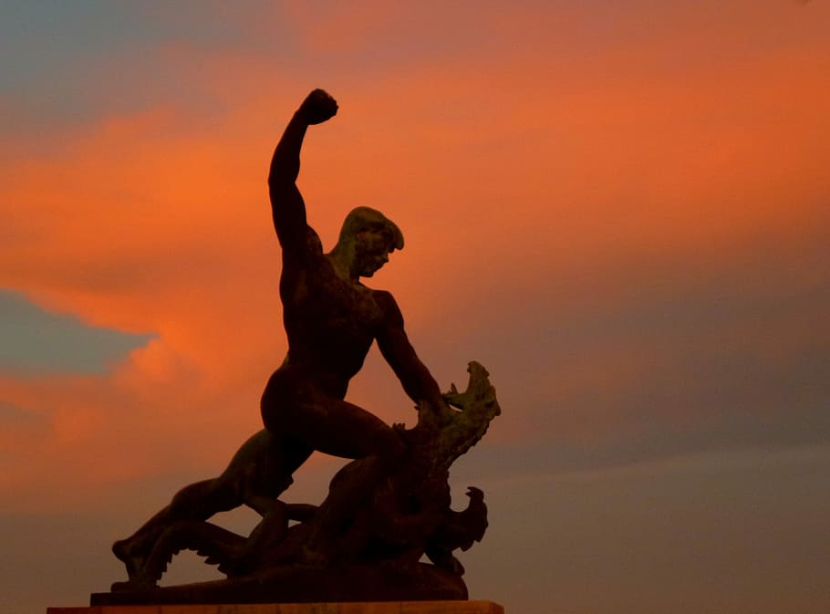 estàtua, posta de sol, llum, lluita, drac, cel, színesfelhő, silueta, a l'aire lliure, rendiment, gent, escultura, representació humana, representació, art i artesania, semblança masculina, color taronja, naturalesa, núvol - cel, cap gent, creativitat, vista d’angle baix, artesania, història, arquitectura, el passat, braços aixecats, 1080P