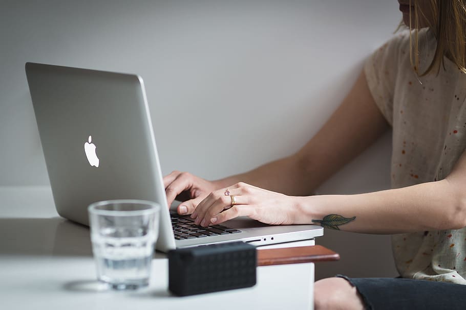kvinde, ved brug af, macbook, glas, vand, bærbar, æble, computer, browser, forskning, skole, forretning, arbejde, skrivebord, kontor, mennesker, trådløs teknologi, teknologi, bruger bærbar computer, en person, meddelelse, voksen, forbindelse, sidder, indendørs, midsection, Kvinder, bord, internet, ung voksen, maskinskrivning, unge kvinder, computer netværk, hånd, 4K