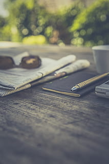 negre, llibre, taula, encara, articles, coses, revista, planificador, bolígraf, al matí, fulls de càlcul, diaris, Notícies, ulleres de sol, mòbil, enfocament selectiu, cap gent, gots, natura morta, primer pla, dia, nivell superficial, a l'aire lliure, centrar-se en primer pla, paper, ulleres, material de fusta, accessori personal, naturalesa, tisores, metall, 5K, CC0, domini públic, lliure de regalies