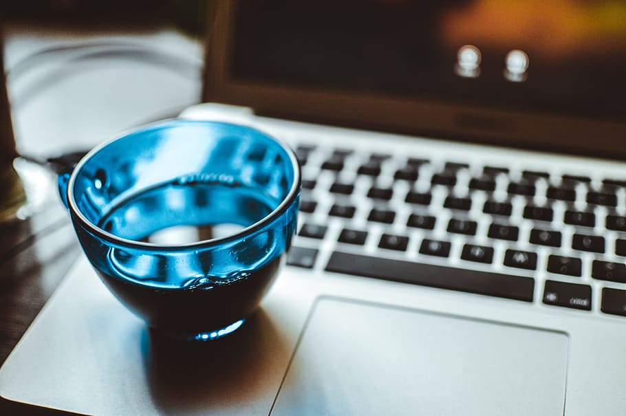 superficiale, fotografia a fuoco, blu, tazza di vetro, computer portatile d'argento, tecnologia, computer, tecnologia wireless, il computer portatile, comunicazione, tavolo, attrezzatura informatica, connessione, avvicinamento, in casa, tastiera, attività commerciale, tastiera del computer, nessuno, bere, cibo e bevande, scrivania, bicchiere, mobilia, 5K