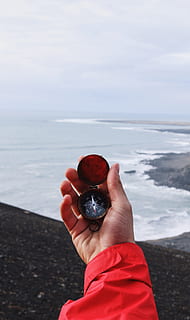 persona amb compàs, persona, celebració, brúixola, assenyalant, nord, capçal de la brúixola, cap al sud, navegar, navegació, penya-segat, oceà, mà humana, mar, una persona, naturalesa, gent, part del cos humà, a l'aire lliure, mà, aigua, persones reals, cel, dia, bellesa a la natura, vermell, persona irreconeixible, fruita, activitat d'oci, platja, escenics - natura, centrar-se en primer pla, horitzó sobre l’aigua, dit, 5K, CC0, domini públic, lliure de regalies