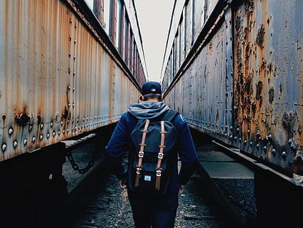 person, walking, trains, daytime, rust, trucks, people, man, guy, boy, snapback, millennials, herschel, backpack, men, one person, rear view, architecture, real people, built structure, bridge, lifestyles, diminishing perspective, three quarter length, transportation, bridge - man made structure, clothing, day, building exterior, casual clothing, standing, direction, outdoors, 1080P, CC0, public domain, royalty free