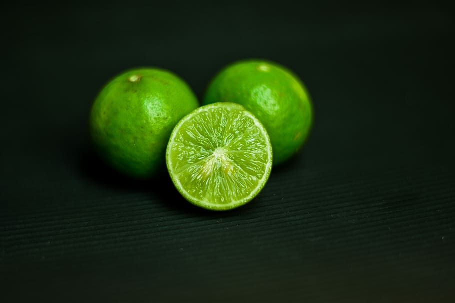 Limone, acido, frutta, lime, frutti acidi, colore verde, agrumi, cibo e bevande, cibo, mangiare sano, fetta, freschezza, benessere, avvicinamento, in casa, sfondo nero, sezione trasversale, natura morta, nessuno, gruppo di oggetti, girato in studio, tavolo, maturo, sapore aspro, 5K
