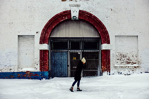 person, walking, snow, architecture, building, infrastructure, structure, establishment, wall, bricks, arc, gate, winter, cold, weather, white, people, woman, bonnet, jacket, boots, outdoors, cold temperature, full length, one person, standing, entrance, building exterior, day, real people, built structure, door, arch, clothing, lifestyles, leisure activity, warm clothing, brick, 2K, CC0, public domain, royalty free