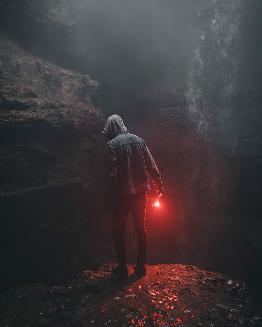 mand, iført, hættetrøje, bedrift, rød, lys, højre hånd, person, leder, hule, flare, anonym, fyr, flamme, underjordisk, ser ned, klint, rejse, fuld længde, stående, en person, klippe, rock-objekt, solid, natur, bagfra, rigtige mennesker, tøj, fritidsaktivitet, livsstil, belyst, røg - fysisk struktur, ung voksen, voksen, afslappet tøj, herrer, hætte - tøj, 5K