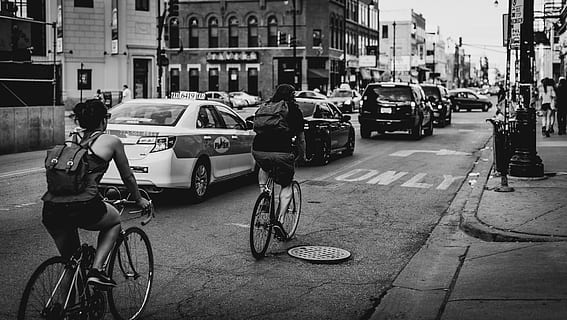 grijswaardenfoto, mensen, fiets, paardrijden, langs, auto's, weg, gebouwen, greyscale, foto, fietsen, op weg, zwart en wit, stedelijke scène, straat, stadsleven, wielersport, stad, vervoer, stadsstraat, wijze van transport, Amsterdam, buitenshuis, landvoertuig, motorvoertuig, architectuur, auto, echte mensen, buitenkant van het gebouw, ingebouwde structuur, levensstijlen, mannen, groep mensen, incidentele mensen, vrouw, 4K, CC0, publiek domein, royaltyvrij