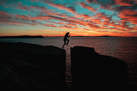 Schattenbildfoto, Mann springt, Cliff, Meer, Sonnenuntergang, Person, Springen, Schlucht, Wolkengebilde, Wolke, Himmel, Horizont, Silhouette, erkunden, Abenteuer, Natur, Ozean, Glaubens Sprung, Sprung, Wasser, Szenen - Natur, Schönheit in der Natur, eine Person, Stehen, Lebensstile, Freizeitbeschäftigung, echte Menschen, Ruhe, ruhige Szene, orange Farbe, wolke - himmel, Strand, Land, Horizont über Wasser, draußen, menschlicher Arm, Arme erhoben, 5K, CC0, gemeinfrei, lizenzfrei